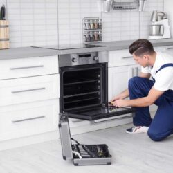 homeguide-oven-repair-technician-fixing-an-oven