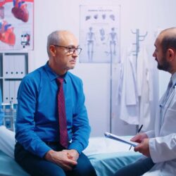old-retired-men-modern-private-clininc-answering-doctor-questionnaire-sitting-hospital-bed-ill-aged-patient-seeking-medical-advice-disease-prevention-from-general-practitioner-modern-pri-min-min