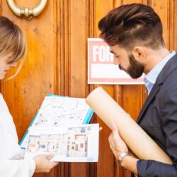 real-estate-agent-looking-plans-front-door_23-2147653367
