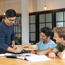 serious-teacher-checking-assignment-two-students-250kb